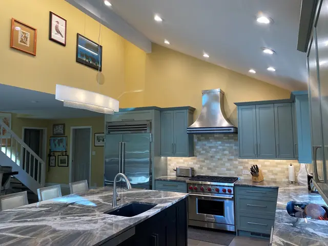 Remodeled kitchen in Alamo with a stone-topped island, range hood and painted cabinets