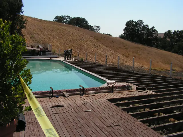 Old deck boards stripped from the framing beside the pool, Danville