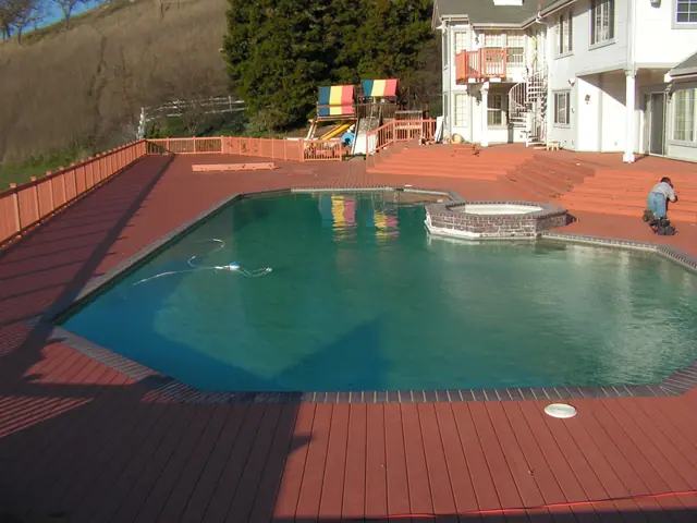 Finished composite deck around the pool in Danville, with the hills behind