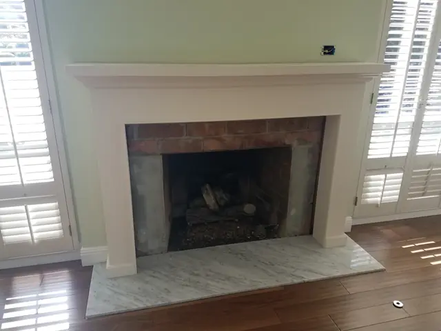Fireplace face-lift in progress, the original red brick exposed inside the mantel