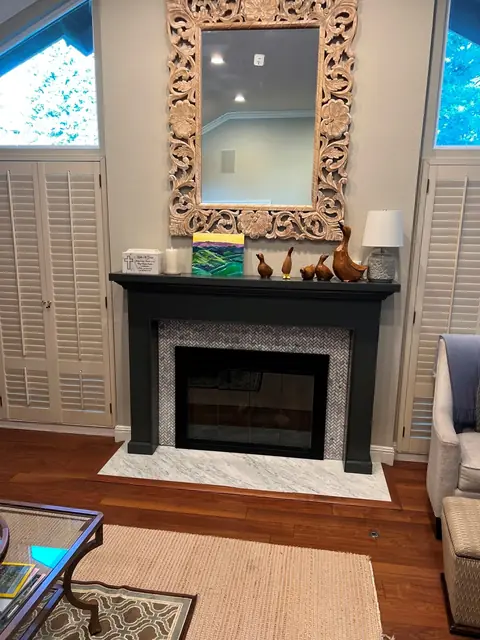 After: fireplace face-lift with a black mantel and stone mosaic surround