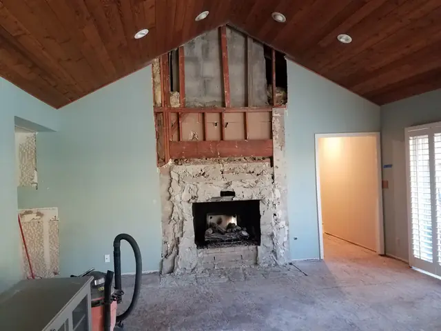 Stripped fireplace wall under the vaulted ceiling, ready for new stone