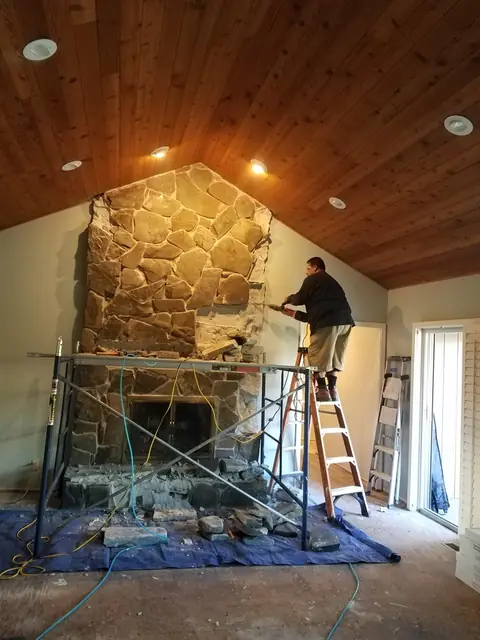 The old stone face being removed from the fireplace
