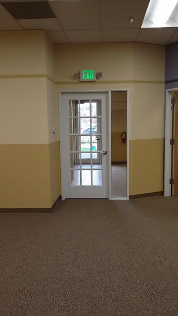 After: glass-paneled exit door at the end of a finished hallway, Huntington Learning Center, Danville