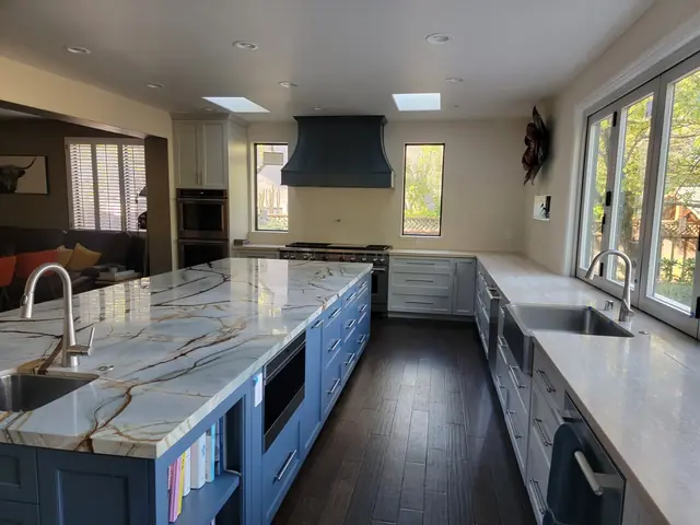 Remodeled kitchen with a blue island and a second sink along the windows