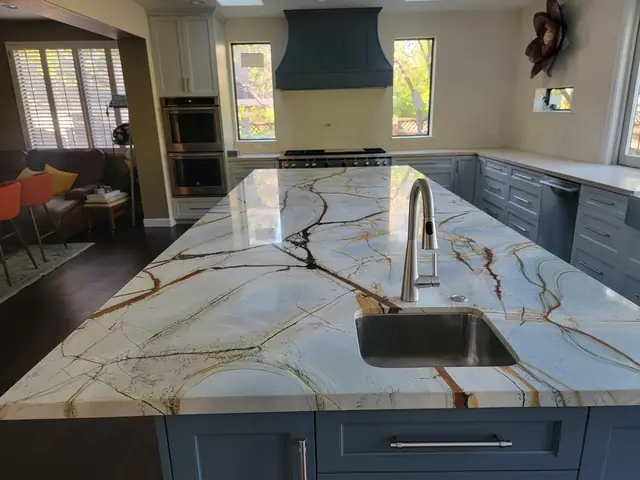 Island sink and veined countertop in the remodeled kitchen