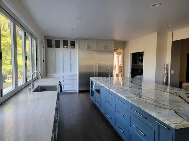Kitchen remodel with a blue island and built-in stainless refrigerator
