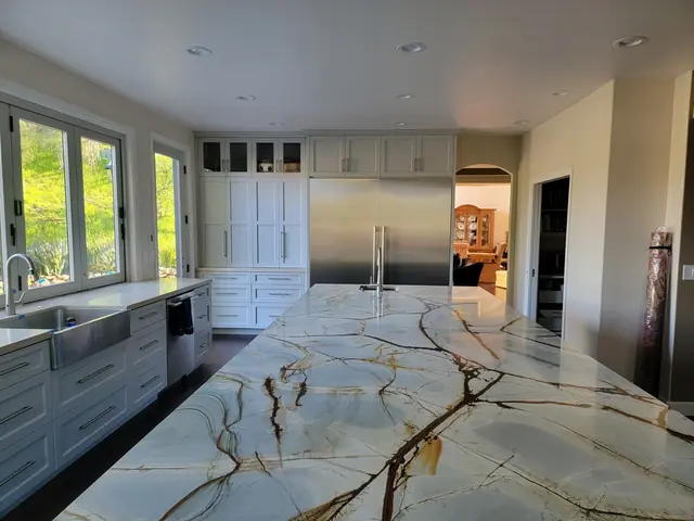 Veined stone island top in the remodeled kitchen, looking toward the windows