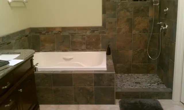 Remodeled Livermore bathroom with a stone-tiled tub surround and walk-in shower