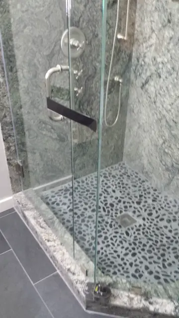 Glass shower and pebble floor in the finished San Ramon bathroom