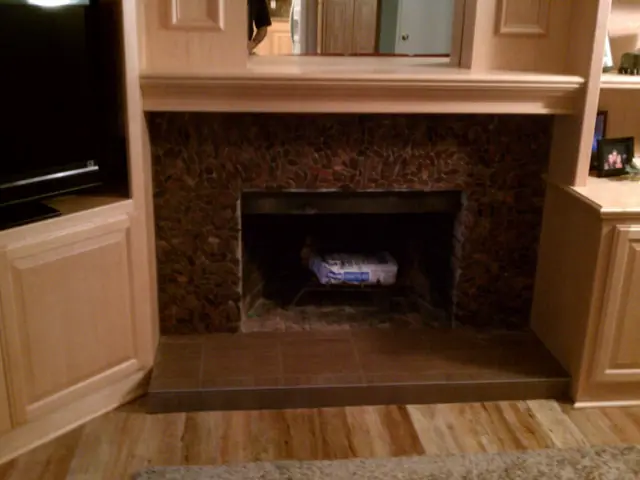 Remodeled San Ramon fireplace with a dark stone tile surround between built-in cabinets