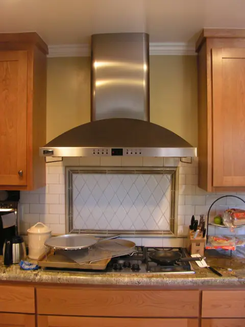 Range hood and tile backsplash framed by cabinets, San Ramon kitchen